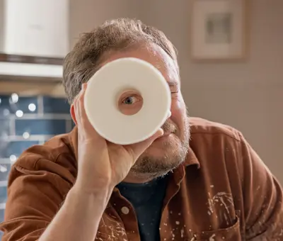 man looking through toilet paper roll